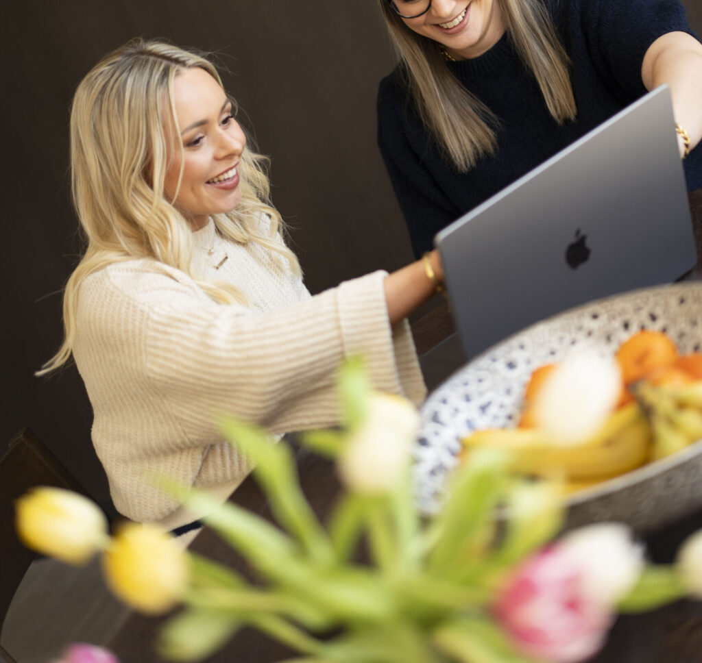 twee vrouwen achter MacBook